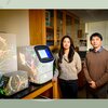 A man and woman standing next to lab equipment.