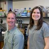 A man and woman standing in front of a lab bench