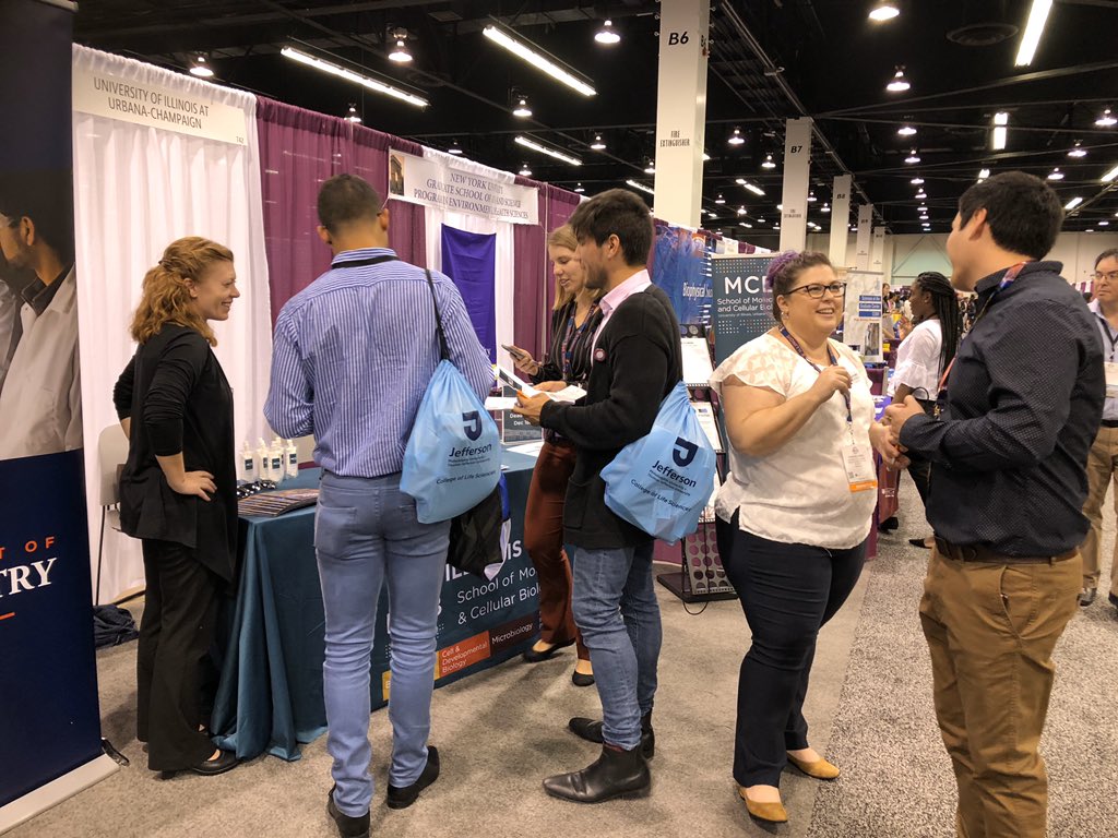 MCB faculty and staff talk with prospective students at a conference.