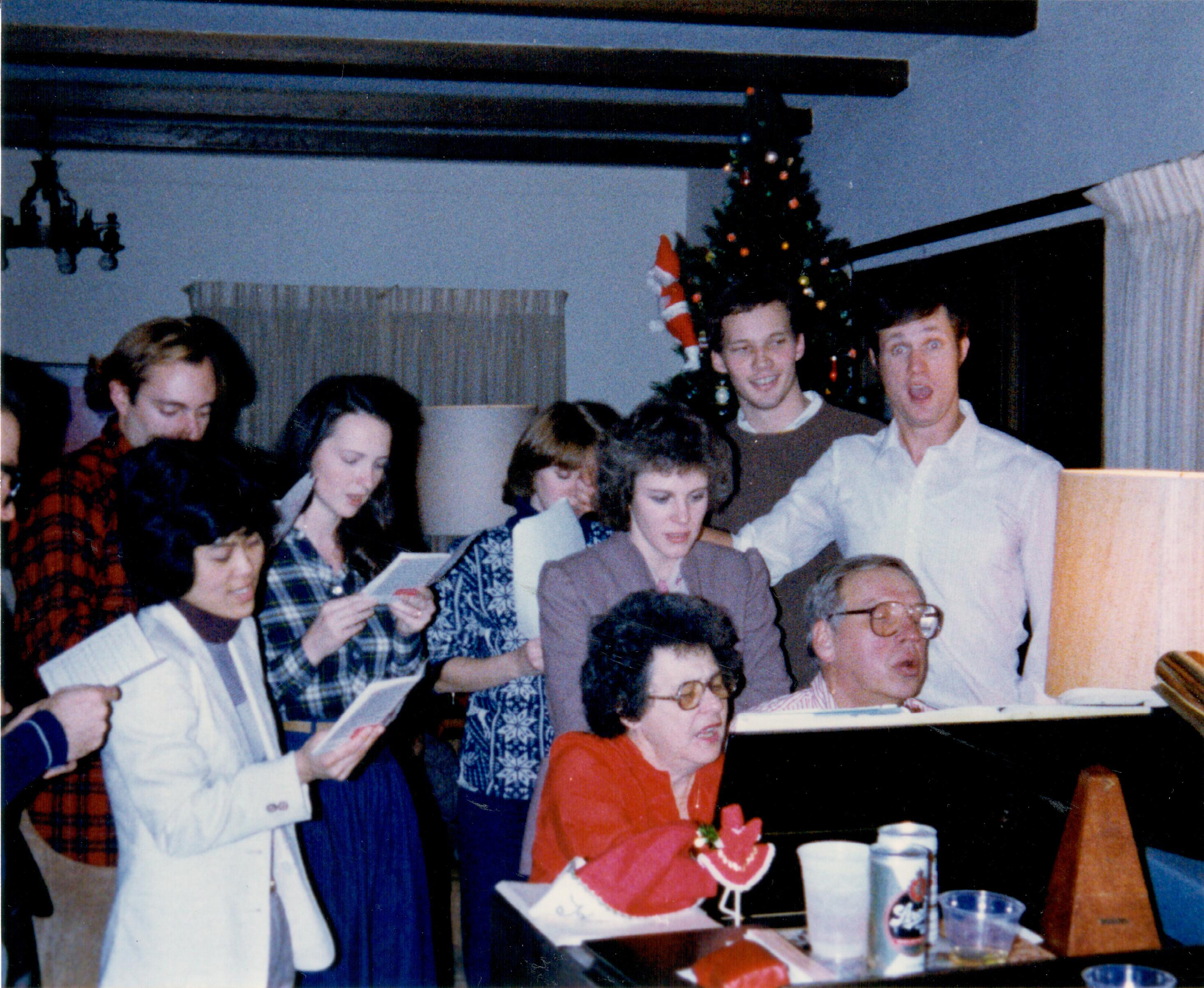 Lowell Hager plays piano as his wife, Fran, and graduate students sing along in 1983.