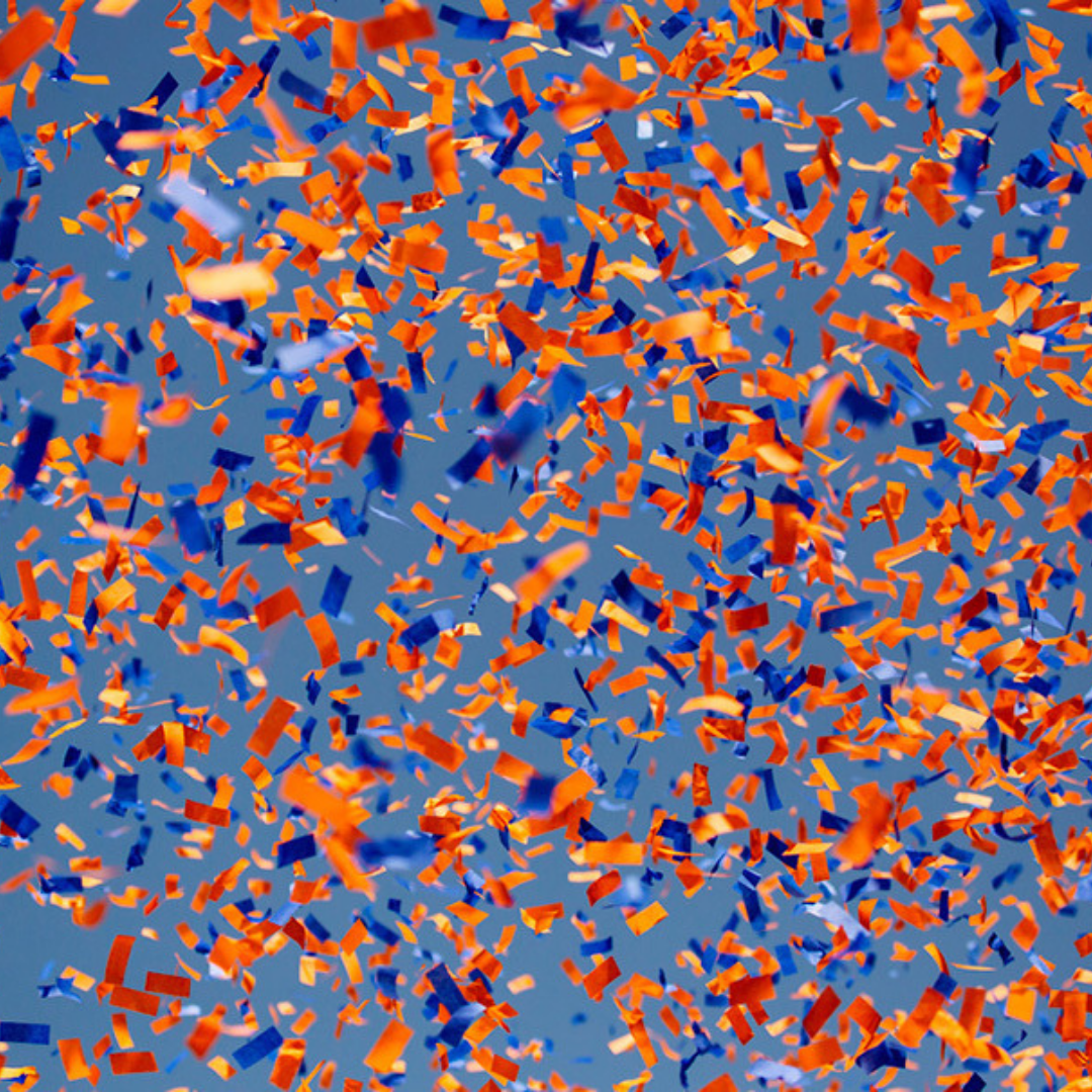 Blue and orange confetti flies in the air.