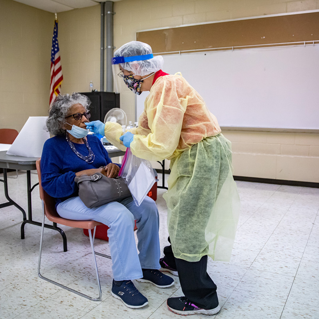 Medical staff use a swab to collect nasal samples from a patient for a PCR COVID-19 test.