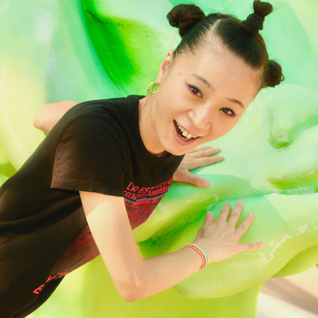 Yumi Iwadate smiles with a green background