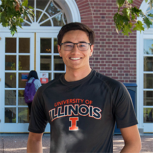 Michael Kraft stands smiling outside Illini Union wearing a U of I t-shirt.