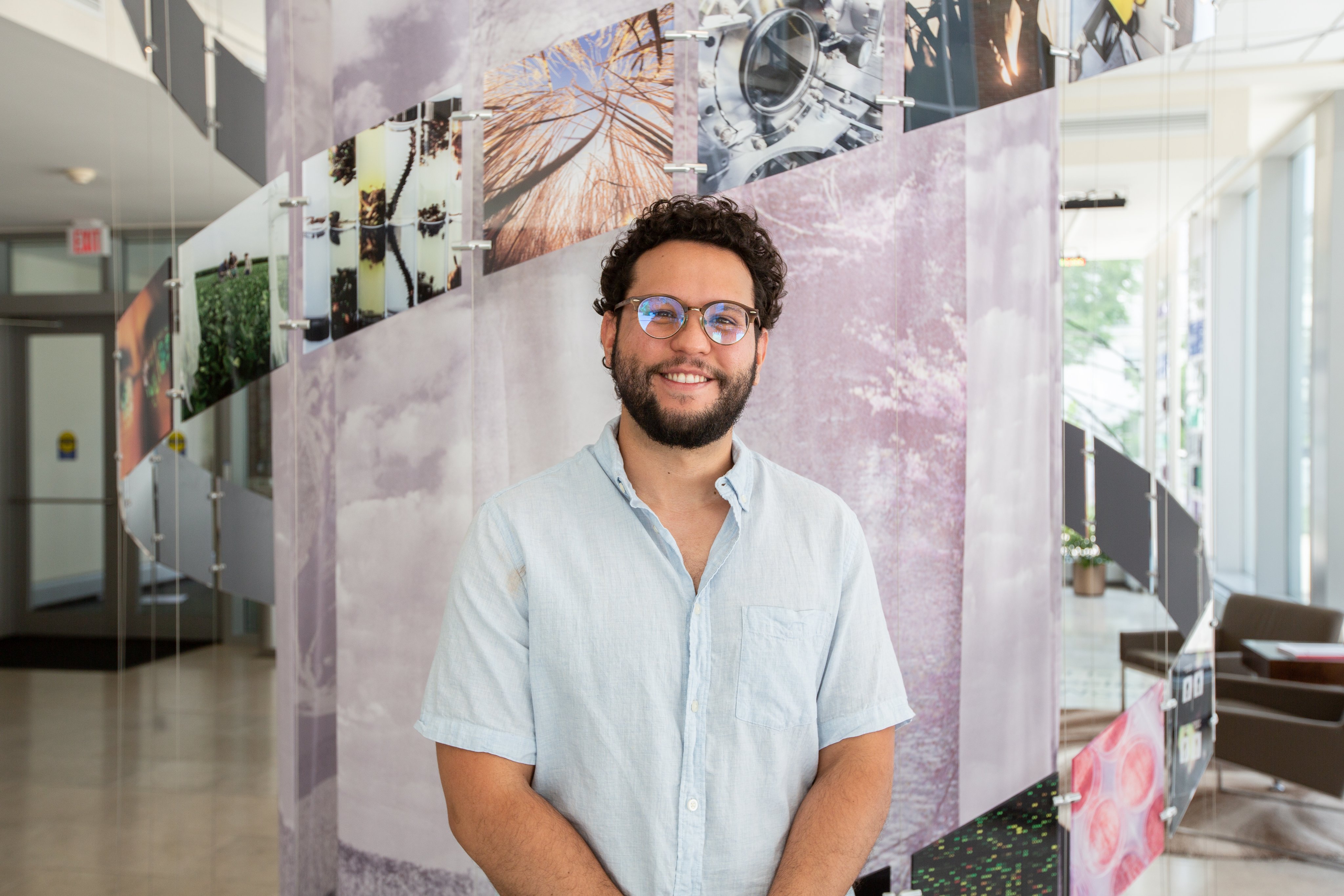 Ruben Sanchez-Nieves stands smiling in the foyer of Carl R. Woese Institute for Genomic Biology.