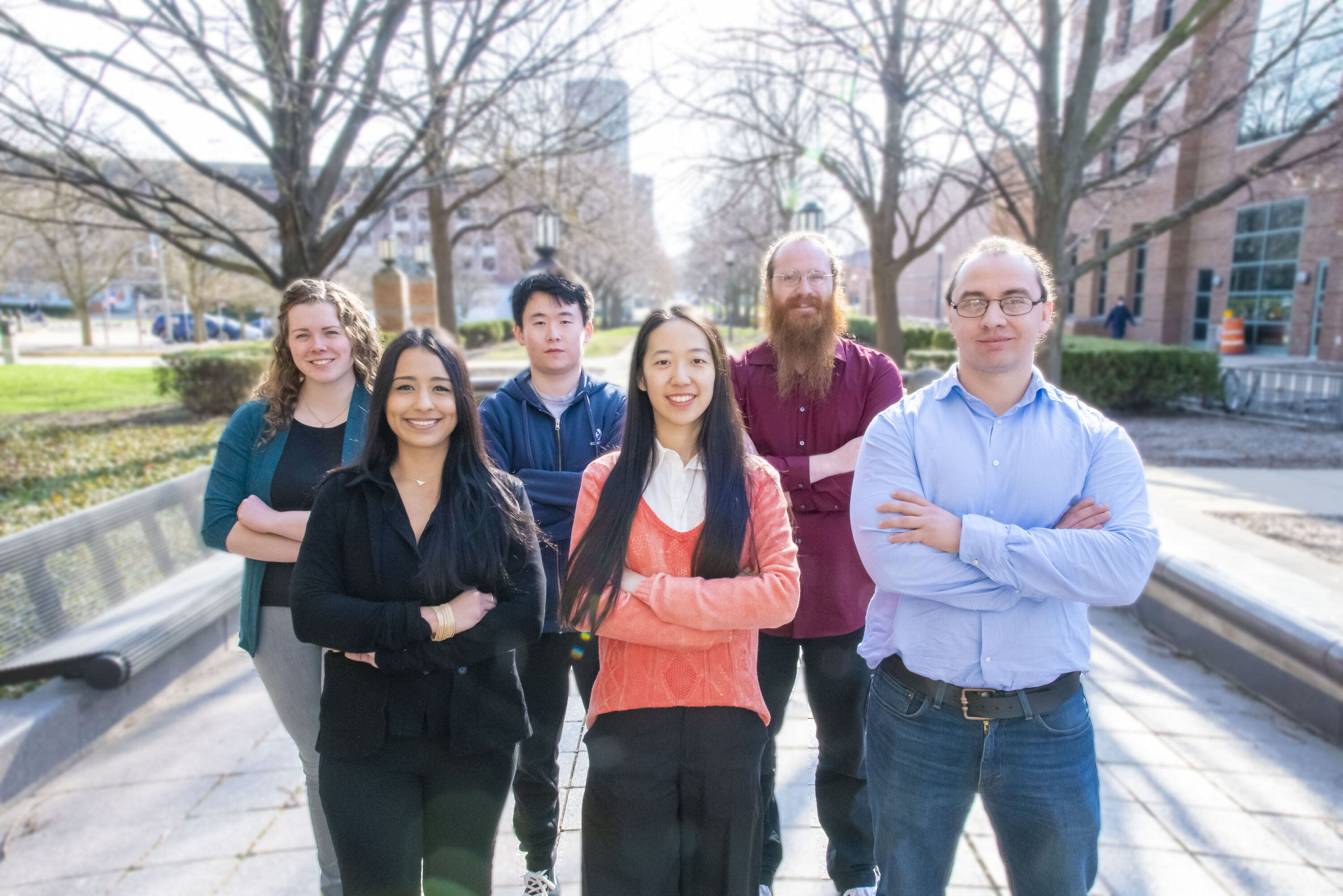The 2023 cohort of the Beckman Institute Postdoctoral Fellows Program (from left): Kelly Powderly; Patricia Cintora; Zhengchang Kou; Yannan Hu; Zane Thornburg; and Alejandro De la Cadena. They are standing outside in a group with arms folded, smiling for the camera.