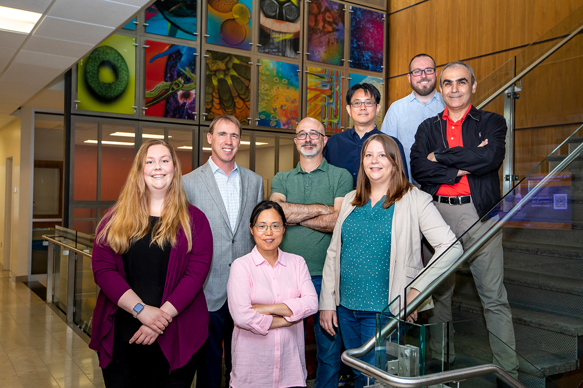 Researchers gather around staircase within the Institute for Genomic Biology