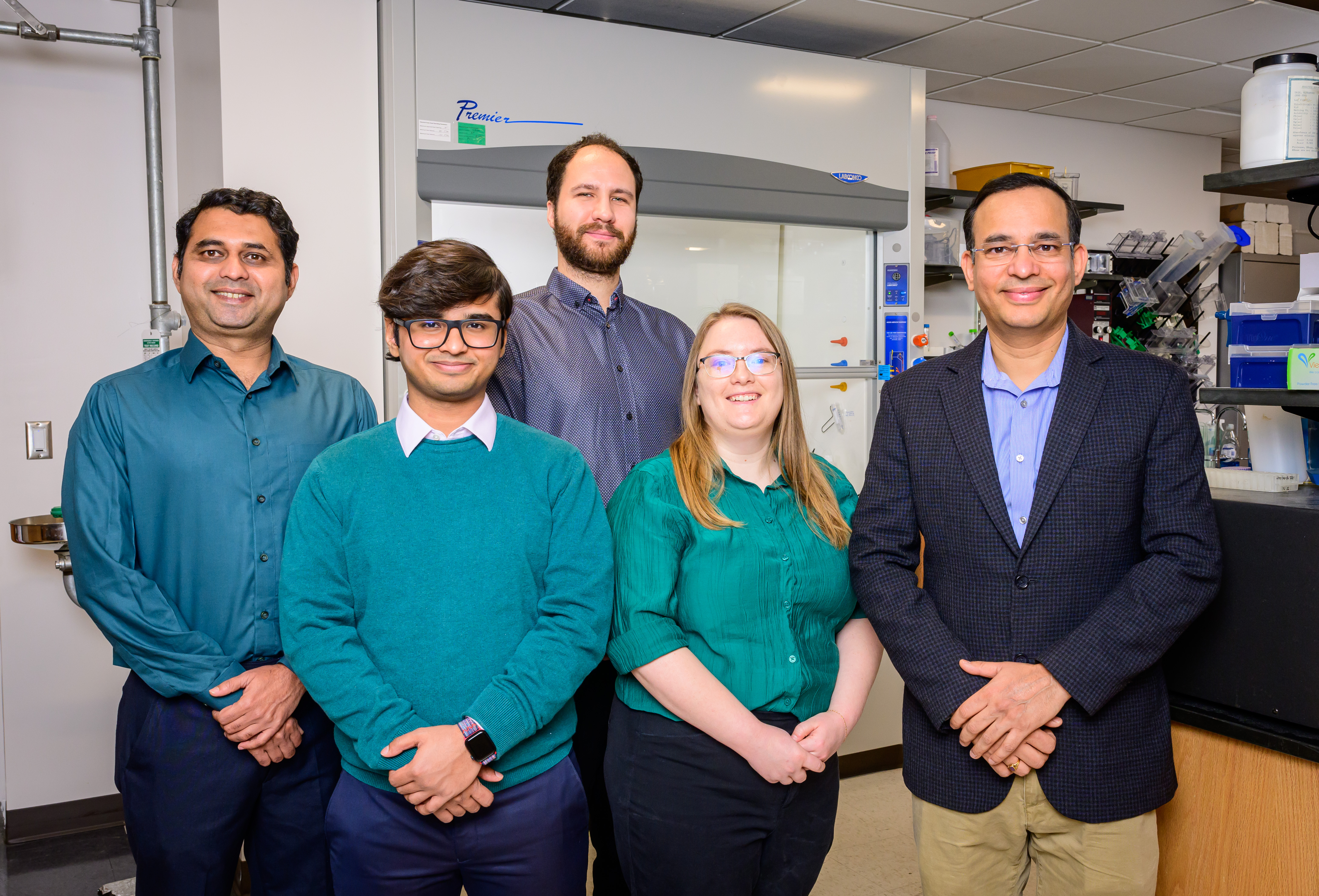 5 researchers standing in a laboratory. 