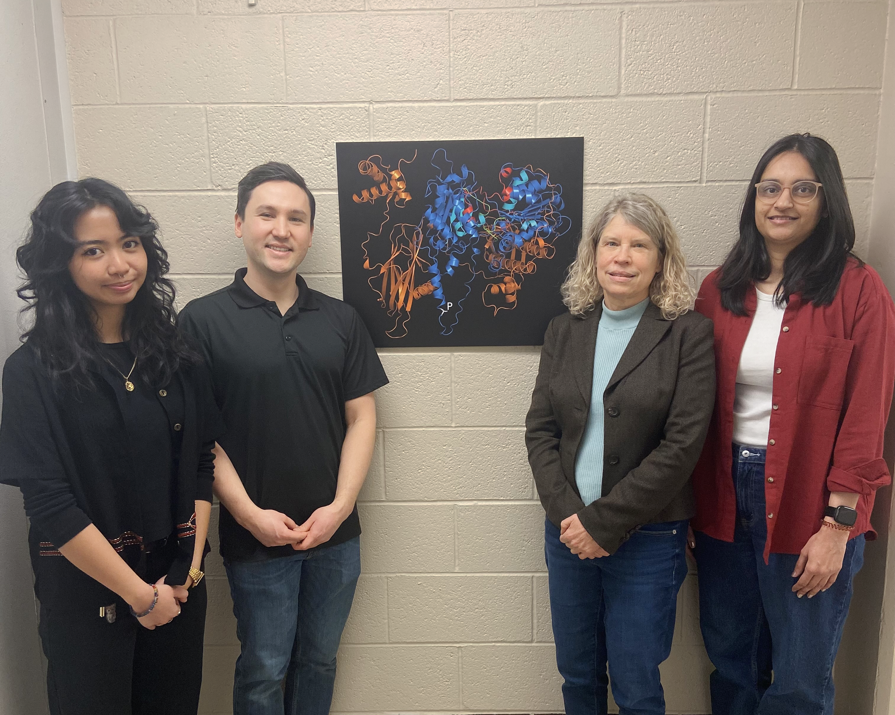 4 people standing next to a poster.