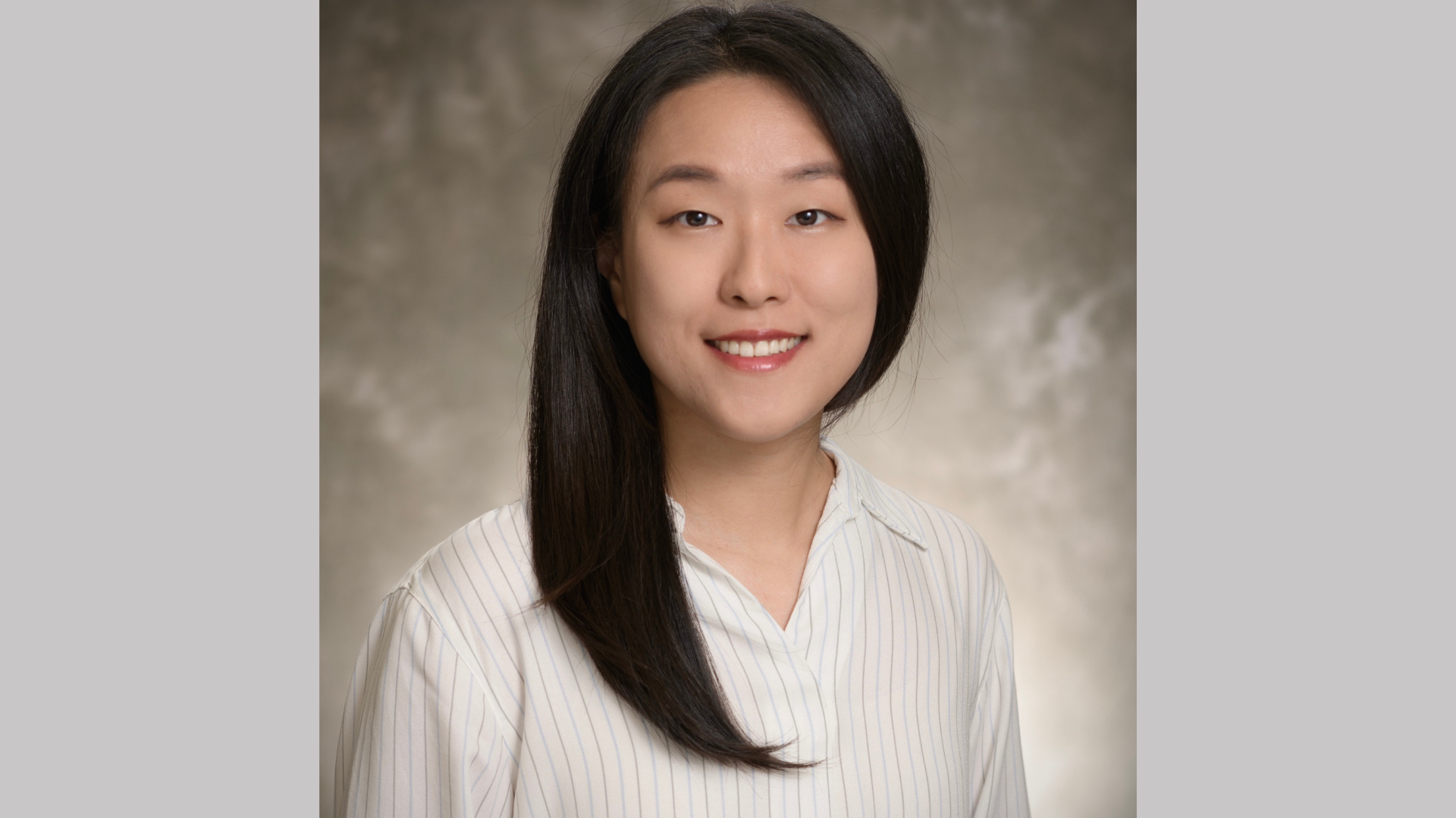 Woman with long black hair wearing white long sleeved shirt