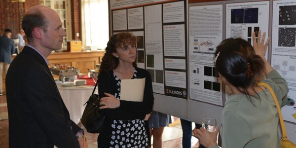 Researcher presents poster at MIP Retreat to two faculty members.