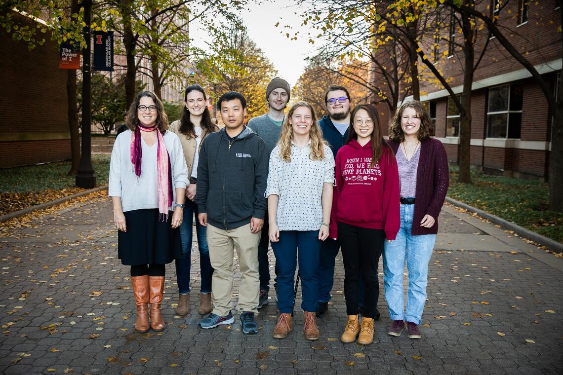 Members of the Rachel Whitaker Lab pose for a photo on a walkway by the Chemical & Life Sciences Laboratory.