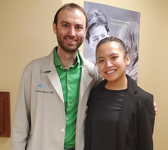 Physcian alum and student mentee pose for photo in office