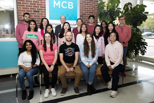 Members of Erik Nelson's research lab gather in the atrium of the Chemical & Life Sciences Laboratory in late 2022.