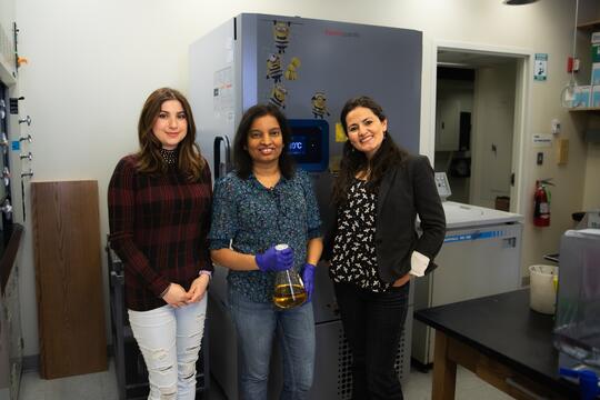 The three microbiologists, research scientist Inoka Menikpurage, graduate student Stephanie Puentes-Rodriguez and PI Paola Mera pose together in front of a lab freezer. 