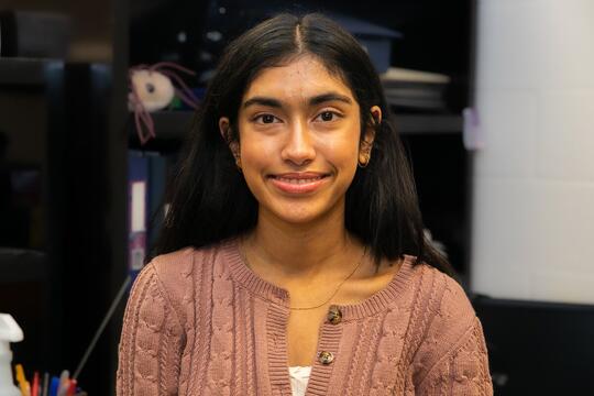 Photo of Neha Ramachandran smiling in lab