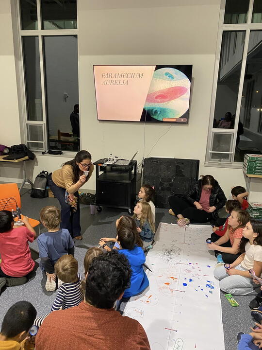 Children gather in the library to watch a science demonstration.