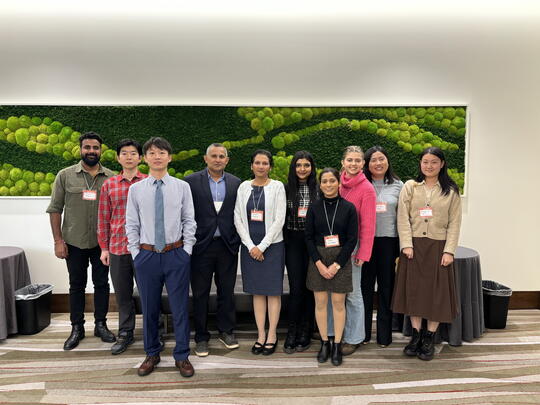 Attendees of the symposium stand for a group photo