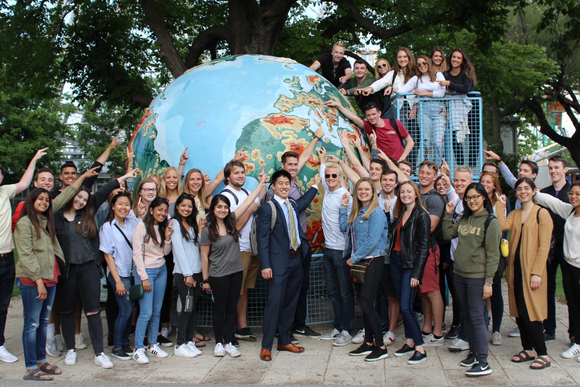 Students gather around a globe in Vienna