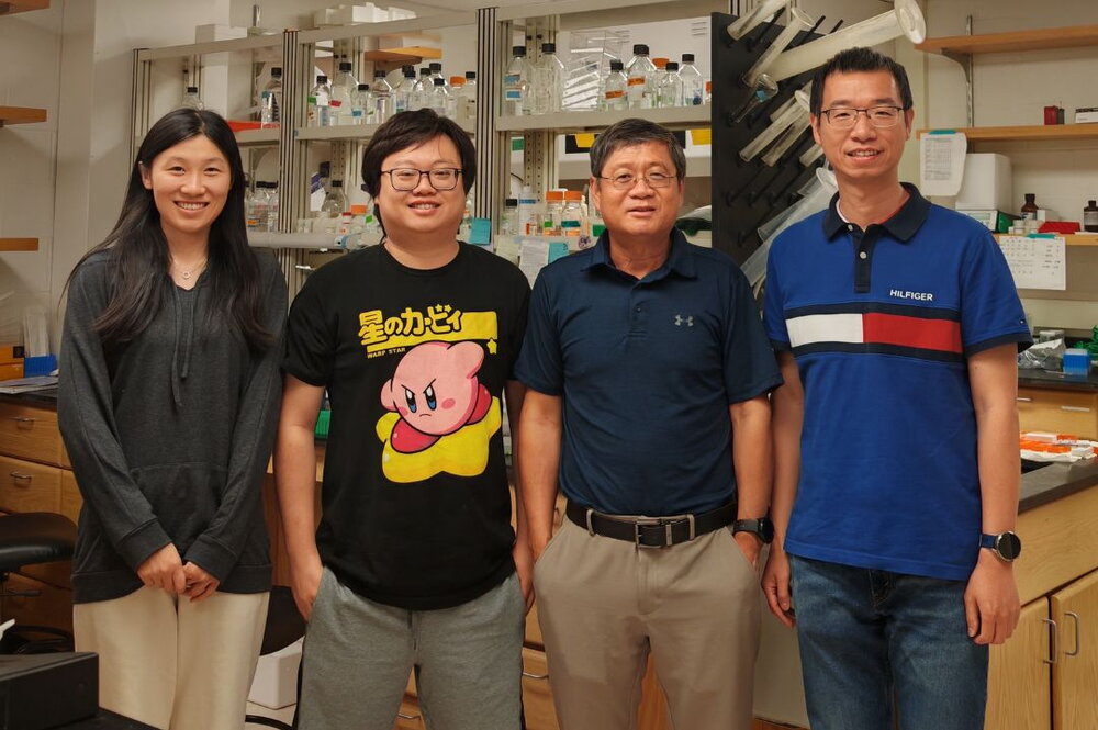 Members of the Lin-Feng Chen lab stand in front of a lab bench