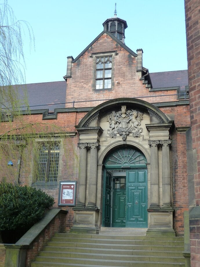Historic brick building on campus with green colored door. 
