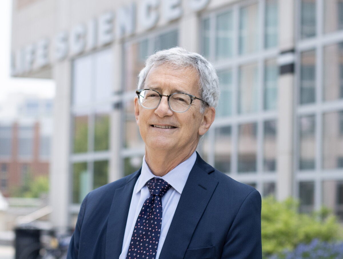 Man in blue suit stands outside life sciences laboratory