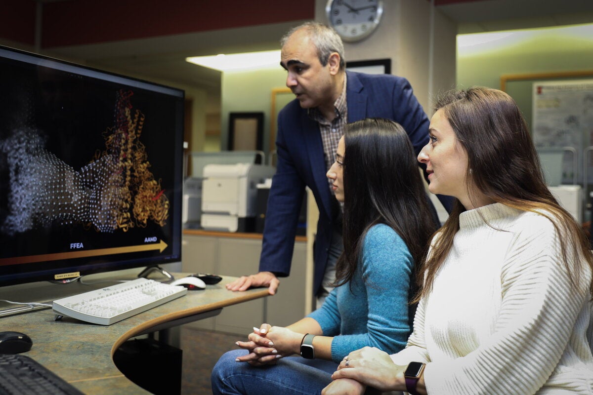 Scientists look at computer with image of protein structure