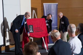 Faculty gather around the plaque honoring UIUC as a milestone in microbiology