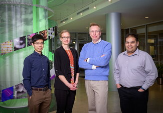 UIUC scientists gather in a line in the IGB atrium.