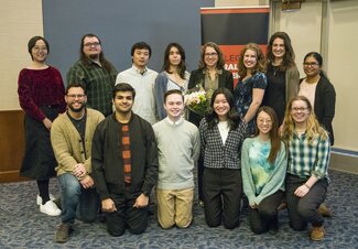 Members of Whitaker Lab pose together for a group photo. There are 13 people in two rows, smiling for the camera.