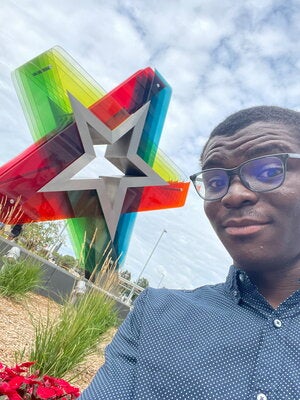 Man stands next to large star sculpture