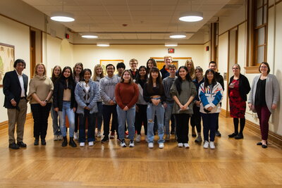 BEST Scholars, MCB and IB directors and advisors pose together, smiling for a group photo.