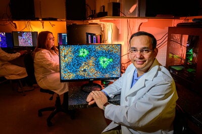 Dr. Kalsotra sits in front of a computer screen