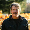 Chris Carpenter, biology alumnus, stares into camera outside in a vineyard. 