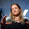 Stefanie Eben gazes at Petri dish in lab.