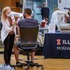 Person in mask gives student a flu shot at a flu shot clinic provided by McKinley Health Center at the University of Illinois.
