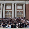 Hundreds of people stand together outside on UIUC's quad in front of Foellinger Auditorium. 