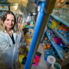 Stefanie Eben looks up at the camera with a smile. She is standing next to an anaerobic chamber. 