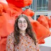 MCB major Catherine Koterba stands outside an orange sculpture at the Carl R. Woese Institute for Genomic Biology