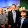 Three researchers standing in front of lab equipment.