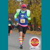 A man running in a blue tank top wearing a pink wig and striped knee socks.