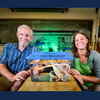 A man and woman sitting next to an octopus tank