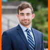 Ben Shapiro wears blue suit and poses in front of steps on Illinois campus