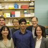 A group of six researchers stand in a lab. 