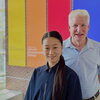 Man and woman stand and smile while in the atrium of laboratory building