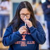 Student spits into funnel tube for saliva sample collection. 