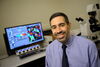 Dan Llano sits at a desk with a computer in the background. 