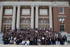 Hundreds of people stand together outside on UIUC's quad in front of Foellinger Auditorium. 