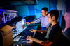 Two men standing in front of a computer.