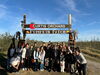 A group of students standing in front of an apple orchard.